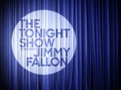 the tonight show starring jimmy falcon on stage with blue curtain and spotlights behind it
