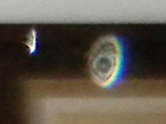 a rainbow is seen in the middle of a blurry image on a camera lens