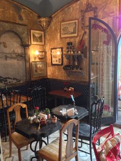 an old fashioned dining room with wooden tables and chairs in the corner, along with pictures on the wall