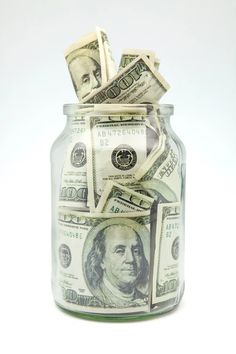 a jar filled with money sitting on top of a table