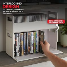 a person is holding a remote control in front of a shelf with dvd's