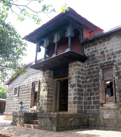 an old brick building with two men sitting on the steps