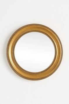 a gold framed mirror hanging on the wall