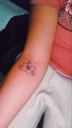 a woman's arm with a small butterfly tattoo on the left side of her arm