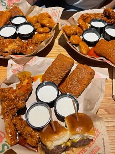 three baskets filled with different types of food on top of a wooden table next to drinks