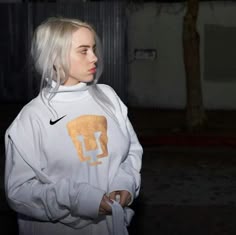 a woman with white hair wearing a nike sweatshirt