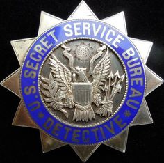 a police badge on a black background with blue and white lettering that reads, segrei service bureau