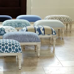 several upholstered footstools in various colors and patterns on the floor,