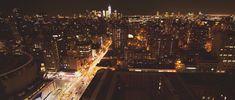 an aerial view of the city lights at night from top of a building in new york