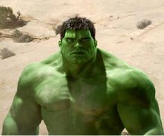 the incredible hulk is standing in front of some rocks and sand with his hands on his hips