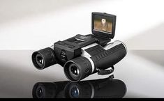 a digital camera sitting on top of a pair of binoculars