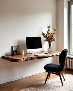 a wooden desk with a computer on it in front of a window and a chair