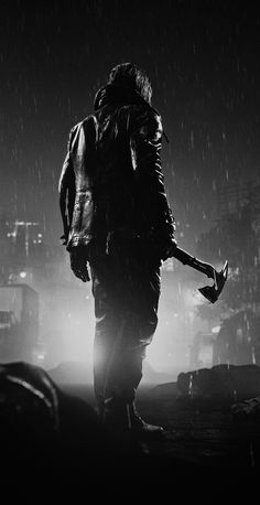 black and white photograph of a person walking in the rain with his back to the camera