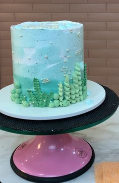 there is a cake on the table with blue frosting and seaweeds around it