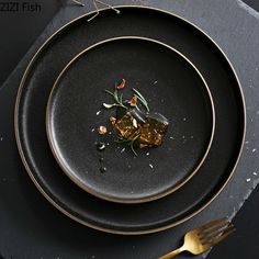 a black plate with some food on top of it and a fork next to it