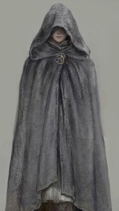 a hooded cloak is shown on display in front of a white wall with a black cat