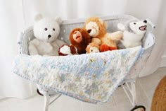 several stuffed animals in a baby crib with a blanket on the floor next to it