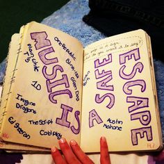 an open book with writing on it and someone's hand pointing at the page