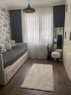 a living room with a couch, bed and curtains