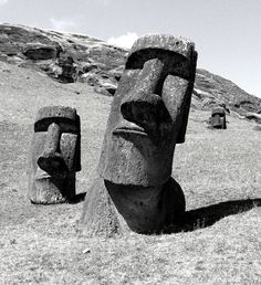 two large sculptures in the grass on a hill