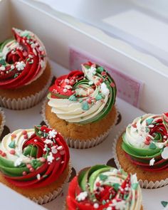 cupcakes decorated with red, green and white frosting in a box for christmas