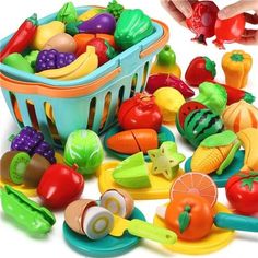 a child's play food set with fruits and vegetables in the basket next to it