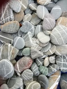 some rocks that are sitting on top of each other in a blue bowl with white lines painted on them