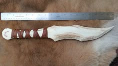 a large knife on top of a brown and white horse's fur with a ruler in the background