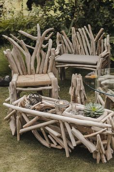 some chairs and tables made out of driftwood are sitting in the grass with succulents on them