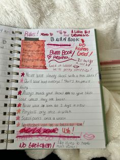 an open notebook with writing on it next to a teddy bear and other items in the background