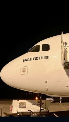 an airplane is parked on the tarmac at night with its door open to let passengers board