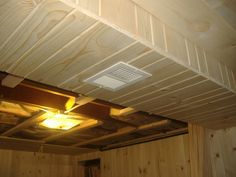 a ceiling fan and light in a room with wood paneling