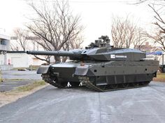 an army tank sitting on the side of a road