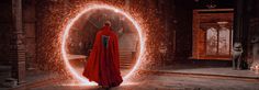 a man in a red cape standing next to a circular doorway with fire coming out of it
