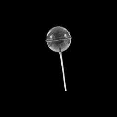 a single lollipop on a black background with the light reflecting off it's side