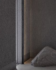 a large rock sitting next to a wall