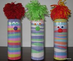 three painted vases with clown faces and hair on them sitting on a wooden table