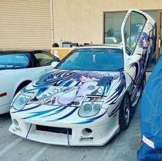 the car is painted with anime characters on it's hood and side door open