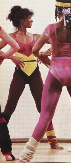 three women in pink and yellow costumes are dancing