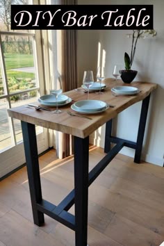 a wooden table with plates and glasses on it in front of a sliding glass door