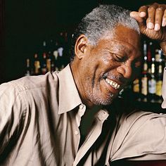 an older man sitting at a bar with his arm on the back of his head