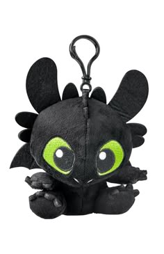 a small black stuffed animal with green eyes