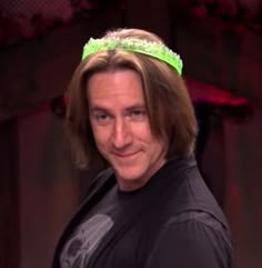 a man with long hair wearing a green headband