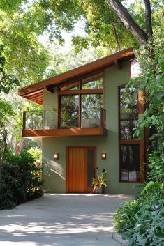 a green house surrounded by trees and bushes