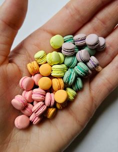 there is a hand that has some small macaroons in it