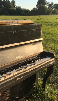 an old piano sitting in the middle of a field