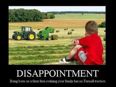 a boy sitting in front of a tractor on top of a field