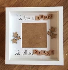 there is a photo frame with scrabbles in it and the words we have a hero