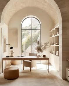 a room with a large arched window and a desk