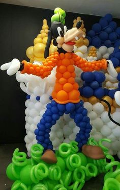 a balloon sculpture is shown in the shape of mickey mouse with balloons surrounding him and his feet